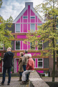 Een kleurrijk huis in Almere, met mensen die toekijken