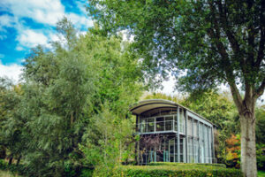 Een gebouw met grote ramen in het groen