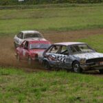een paar auto's crossen in een grasveld