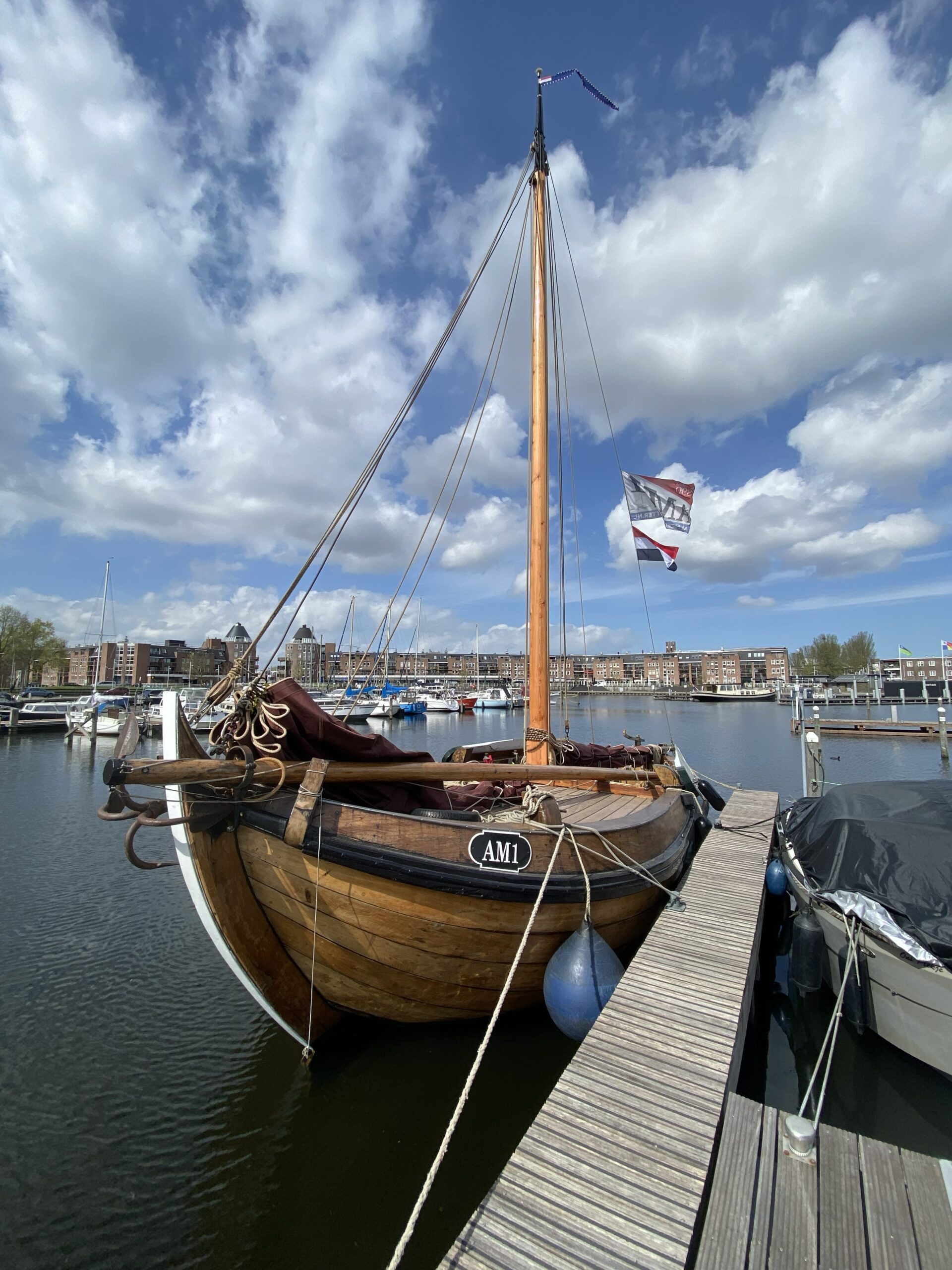 De Almeerse Botter ''AM1'' te water aan een steiger.