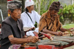 Mensen in traditionele klederdracht van Indonesie zitten achter een instrument